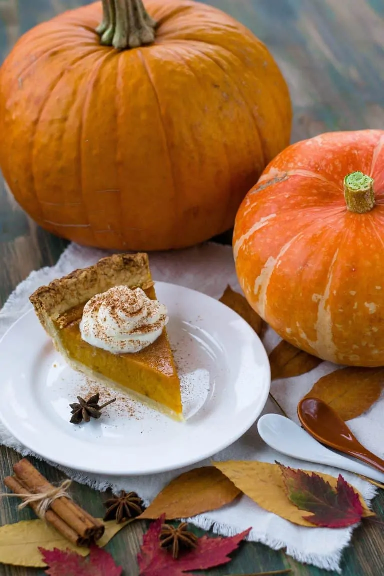 Pumpkin pie with whipped cream and cinnamon